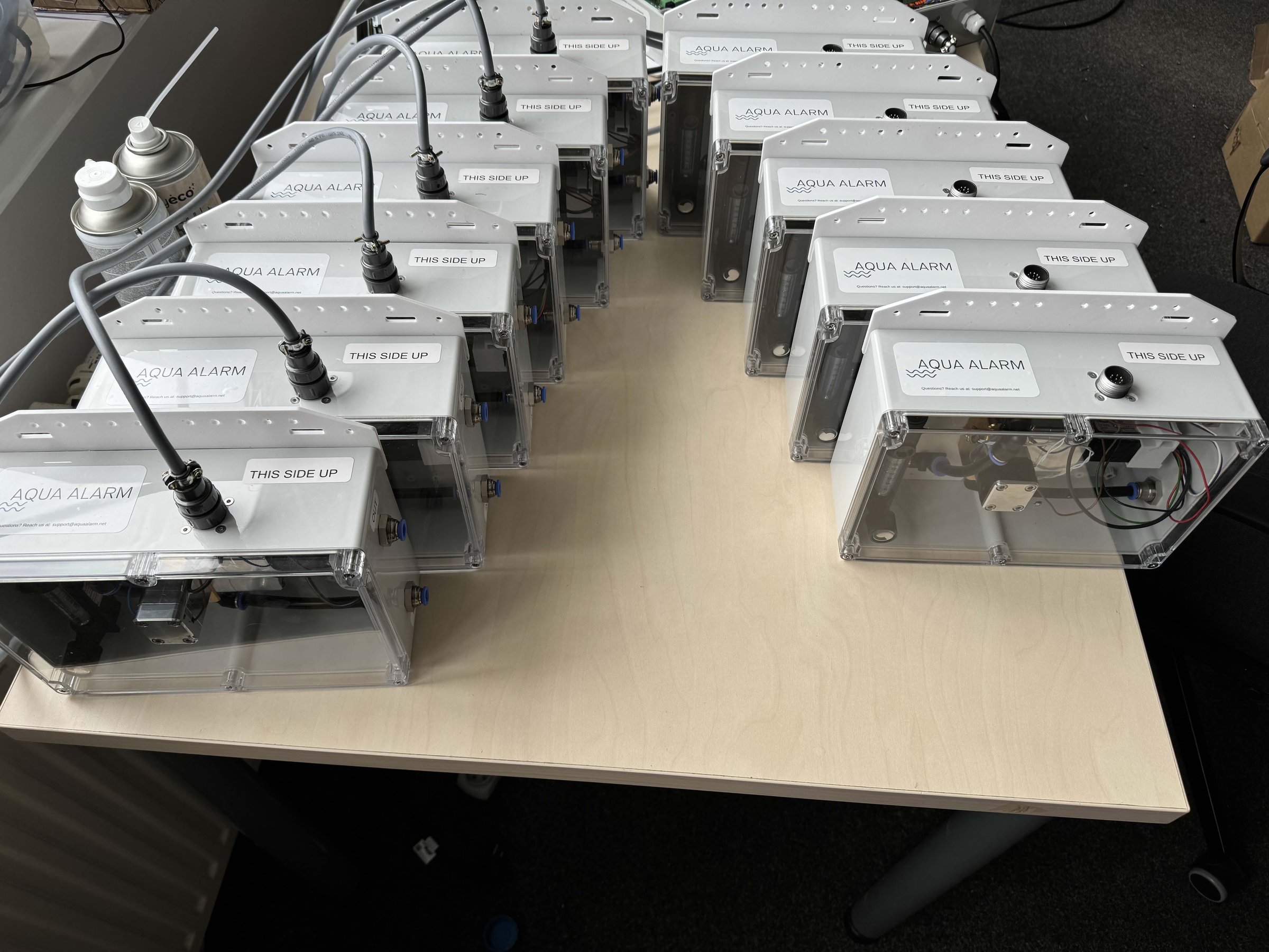 A row of Aqua Alarm sensor units in progress on an assembly bench