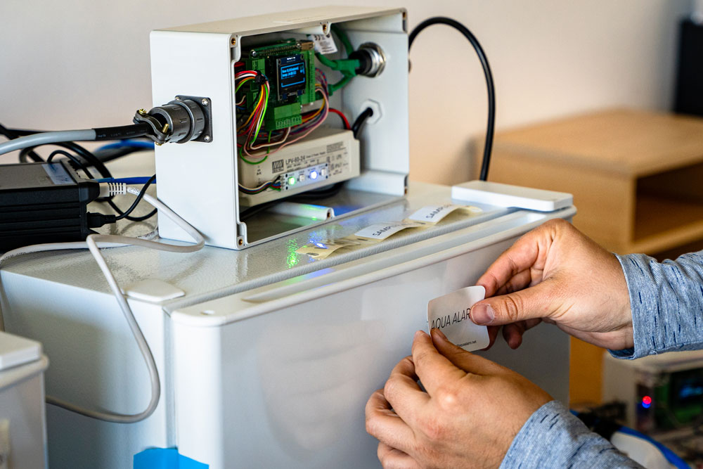 Applying the Aqua Alarm brand label to a finished autosampler unit